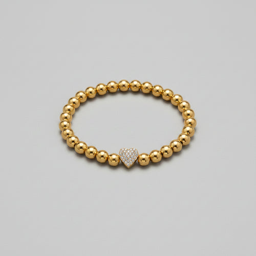 Gold beaded bracelet with a heart-shaped clasp on a white background